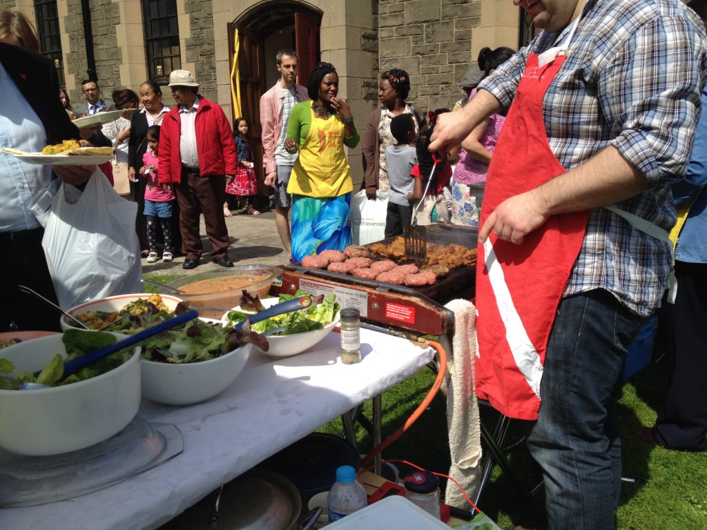 A multicultural crowd queues for a barbecue in Leith, Edinburgh